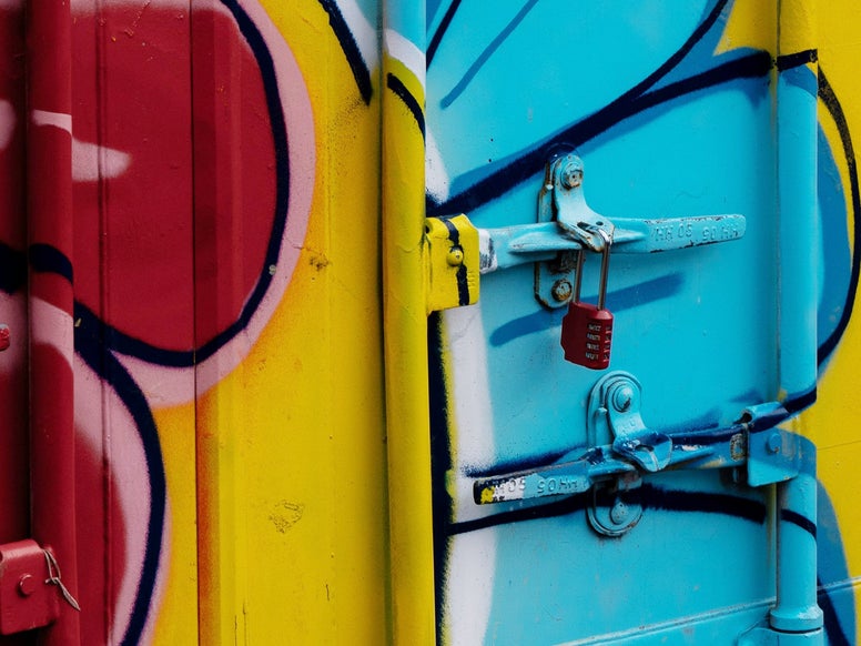 Closeup of a container with a padlock. There is colorful graffiti on the container. Picture by Fer ID on Pexels.
